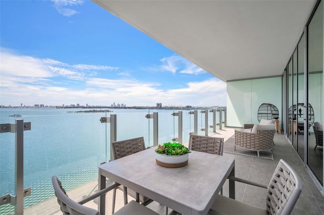 balcony with an outdoor living space and a water view