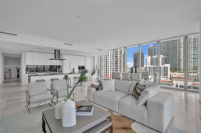 living area featuring a view of city, floor to ceiling windows, and visible vents