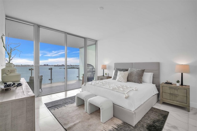 bedroom featuring access to exterior, expansive windows, and a water view