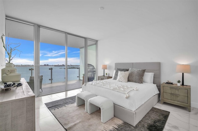 bedroom with a water view, a wall of windows, access to exterior, and multiple windows