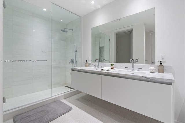 bathroom with a shower with door, vanity, and tile patterned flooring