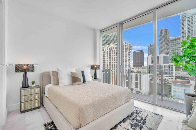 bedroom with access to outside, a city view, multiple windows, and a wall of windows