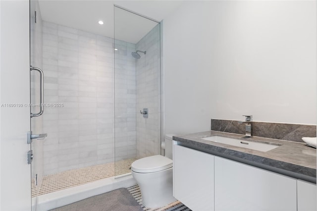 bathroom with tiled shower, vanity, toilet, and tile patterned flooring