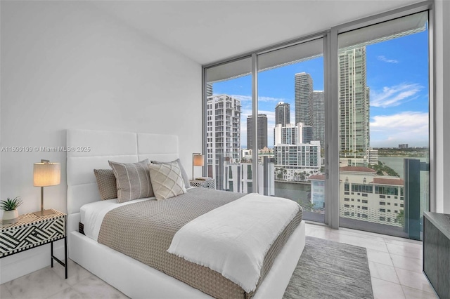 bedroom featuring a wall of windows, a view of city, tile patterned floors, a water view, and access to outside