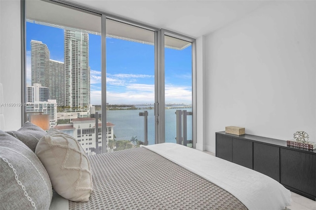 bedroom featuring a water view and expansive windows