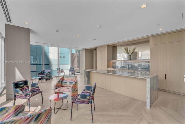 kitchen with light stone counters, floor to ceiling windows, light brown cabinetry, and light parquet floors