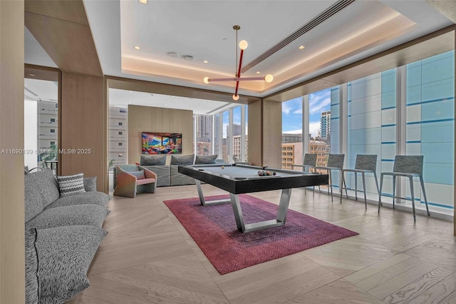 playroom with a view of city, a raised ceiling, pool table, and floor to ceiling windows