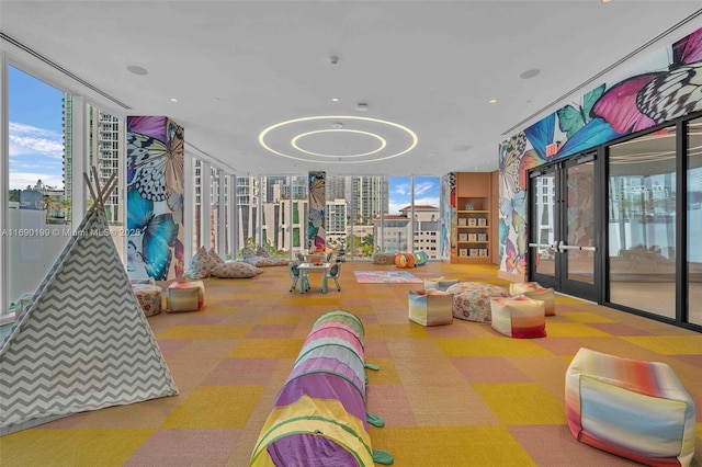 playroom featuring floor to ceiling windows, carpet floors, and french doors