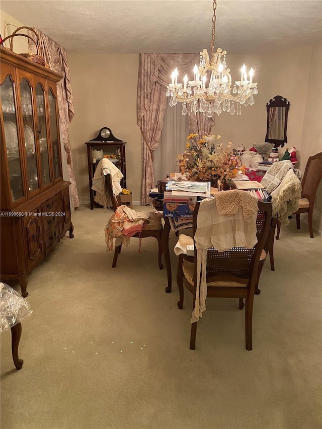 dining room featuring light carpet, a textured ceiling, and an inviting chandelier