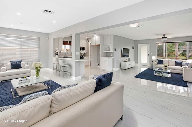 living room with ceiling fan and sink