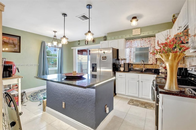 kitchen featuring light tile patterned flooring, a kitchen island, white cabinetry, stainless steel refrigerator with ice dispenser, and sink