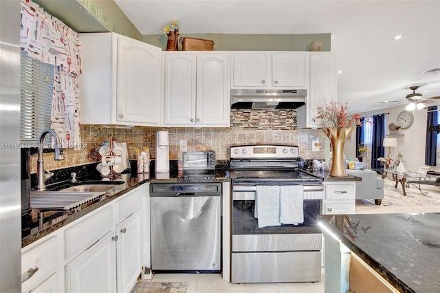 kitchen featuring stainless steel appliances, dark stone countertops, and white cabinetry