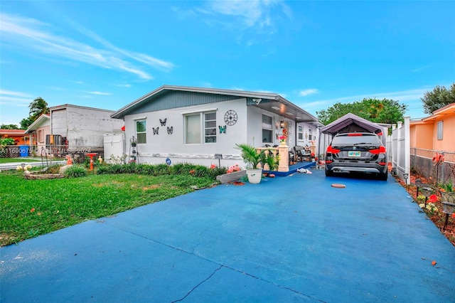 view of front of property featuring a carport and a front lawn