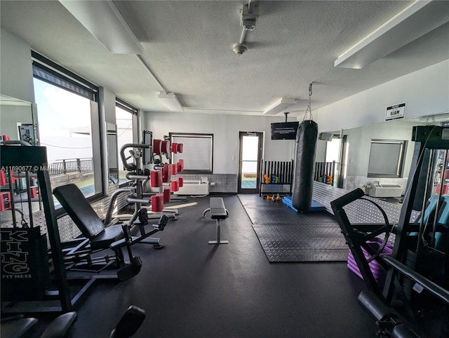 gym featuring plenty of natural light and a textured ceiling