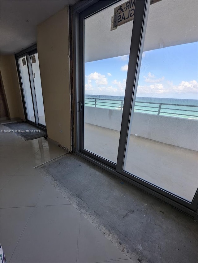 unfurnished room with a water view and a view of the beach