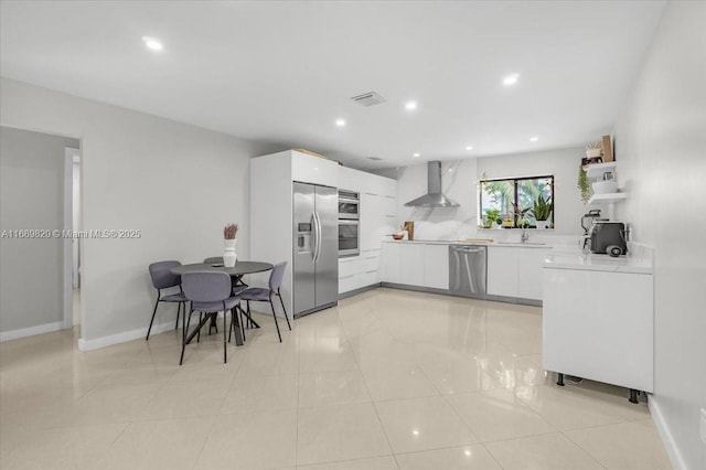 kitchen featuring white cabinetry, wall chimney range hood, modern cabinets, and appliances with stainless steel finishes