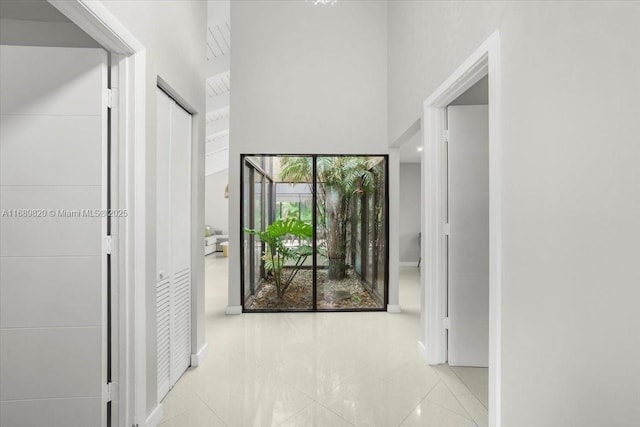 corridor with tile patterned floors and baseboards