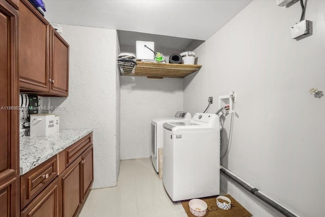 clothes washing area featuring cabinet space and washing machine and clothes dryer