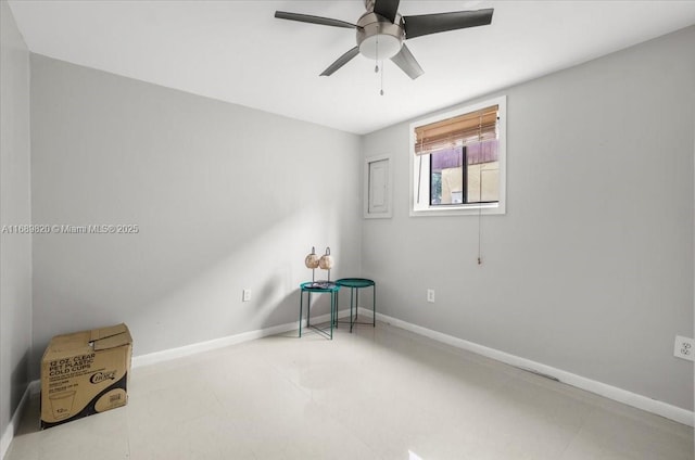 interior space with baseboards and a ceiling fan