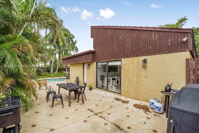 view of patio / terrace with a fenced in pool, a grill, outdoor dining space, and fence