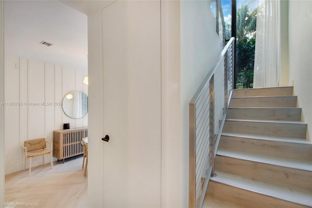 stairs with hardwood / wood-style flooring and a healthy amount of sunlight