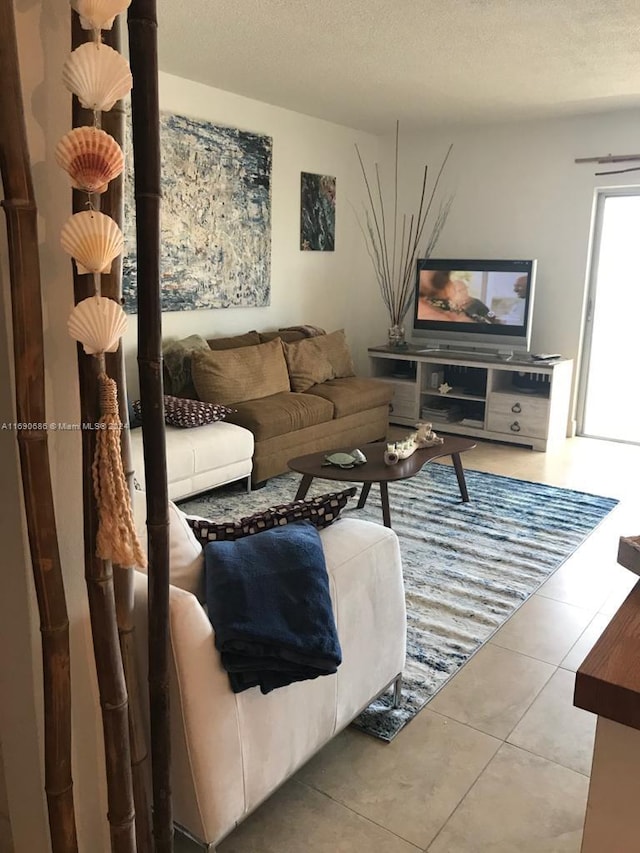 tiled living room featuring a textured ceiling