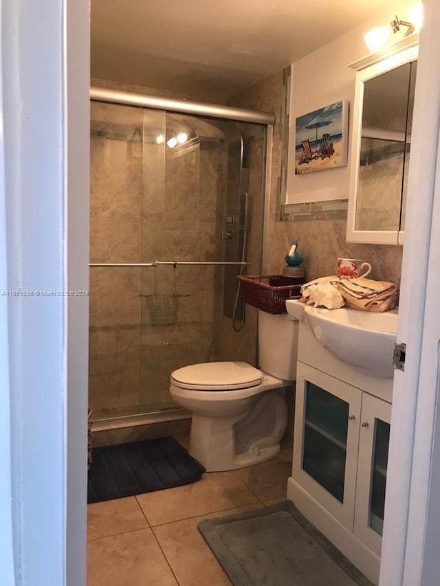 bathroom with vanity, tile patterned floors, an enclosed shower, and toilet