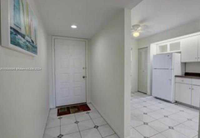 interior space featuring white cabinets, ceiling fan, and white fridge