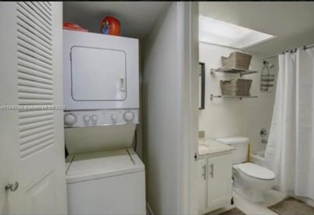 clothes washing area featuring stacked washer / dryer