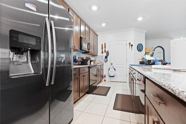 kitchen featuring sink, appliances with stainless steel finishes, light stone countertops, light tile patterned floors, and crown molding