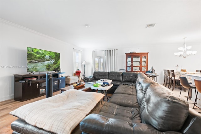 living room featuring light hardwood / wood-style floors, a chandelier, and crown molding