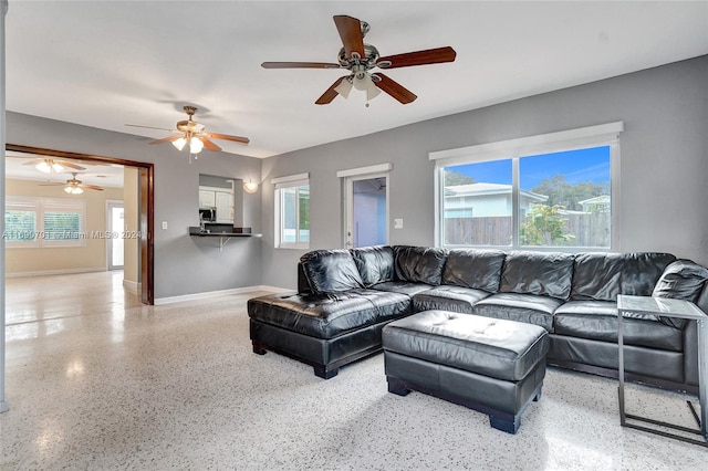 living room featuring ceiling fan and plenty of natural light