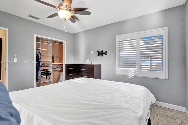 bedroom featuring a walk in closet, ceiling fan, and a closet