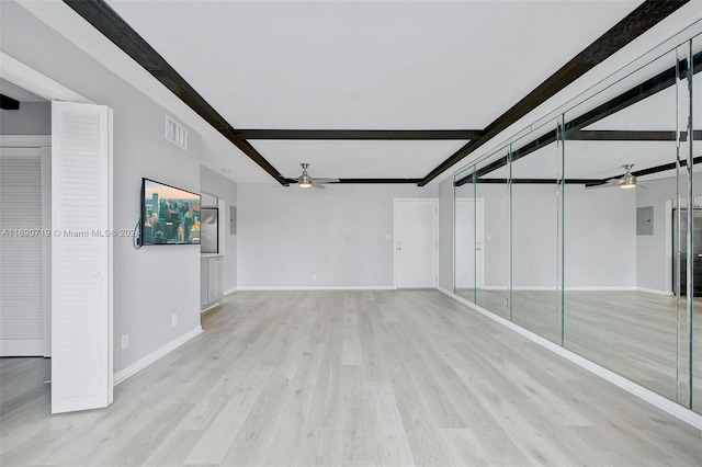 spare room featuring light hardwood / wood-style floors, beamed ceiling, and ceiling fan