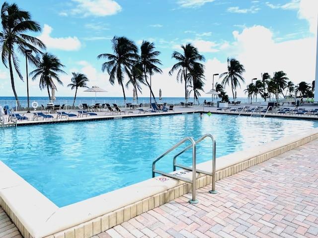 view of pool featuring a water view and a patio area