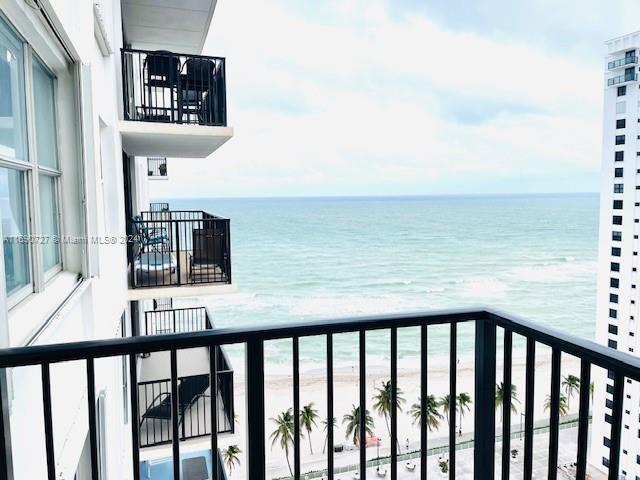 balcony with a water view and a beach view