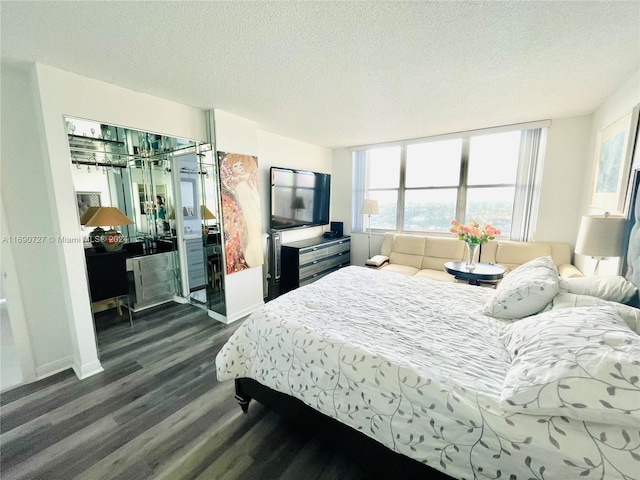 bedroom with dark hardwood / wood-style floors and a textured ceiling