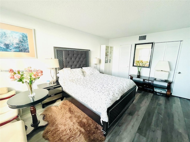 bedroom featuring a textured ceiling and dark hardwood / wood-style flooring