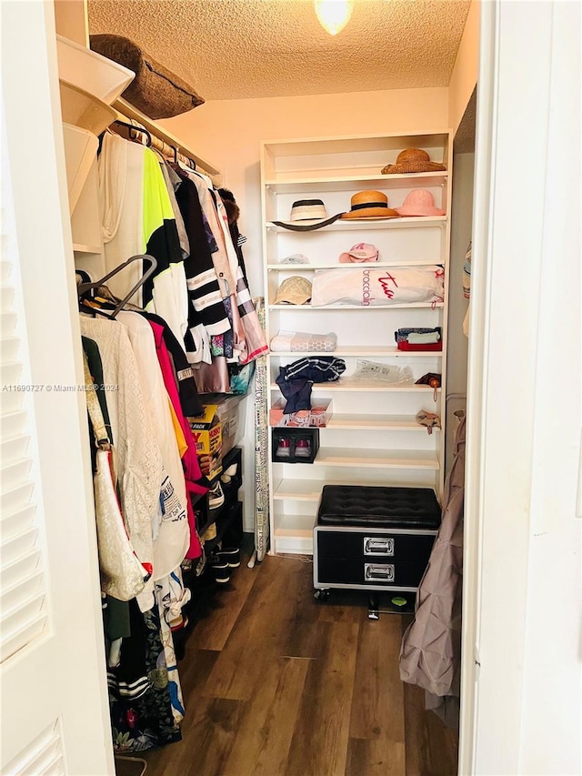 spacious closet with dark hardwood / wood-style flooring