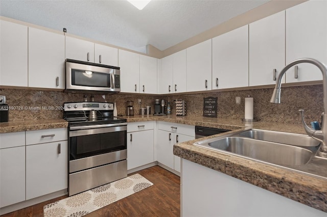 kitchen with dark hardwood / wood-style flooring, a textured ceiling, sink, white cabinetry, and appliances with stainless steel finishes