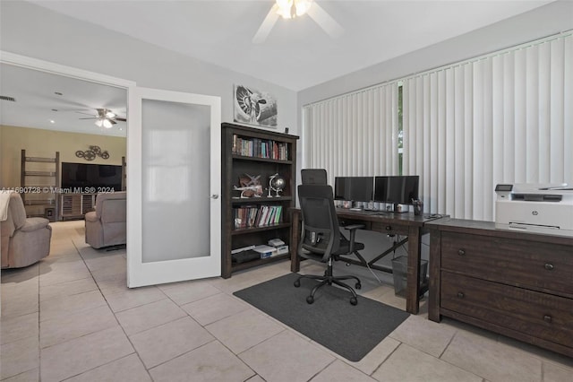 office featuring lofted ceiling, light tile patterned floors, and ceiling fan