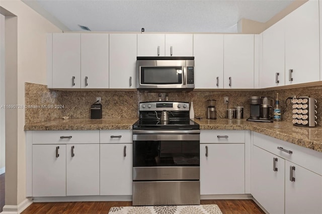 kitchen featuring light stone counters, appliances with stainless steel finishes, dark hardwood / wood-style floors, backsplash, and white cabinets