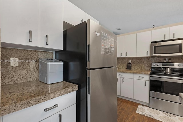 kitchen featuring white cabinetry, appliances with stainless steel finishes, dark wood-type flooring, and backsplash