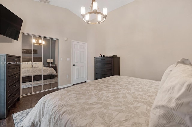 bedroom with a chandelier, a closet, dark wood-type flooring, and lofted ceiling