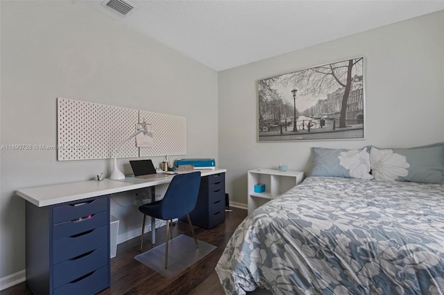 bedroom with dark hardwood / wood-style flooring and built in desk