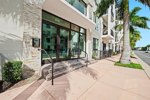 view of exterior entry with a balcony