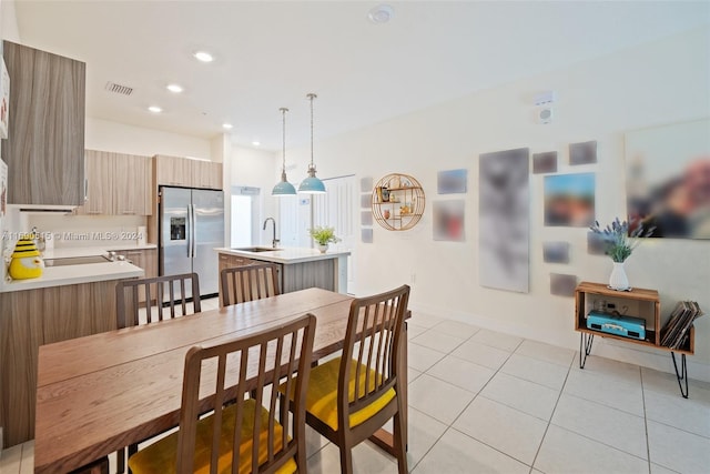 dining space featuring sink and light tile patterned floors