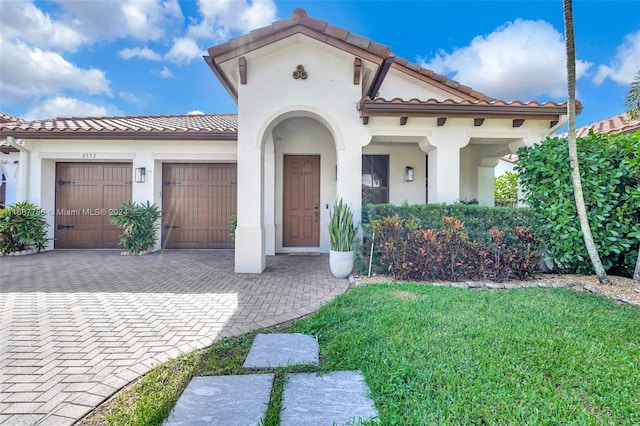 mediterranean / spanish-style house featuring a garage and a front yard