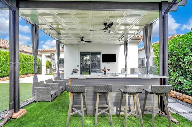 view of patio / terrace with exterior bar and ceiling fan