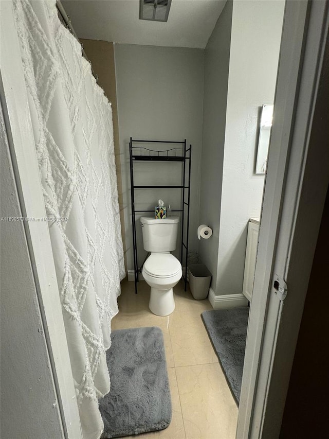 bathroom with toilet and tile patterned floors